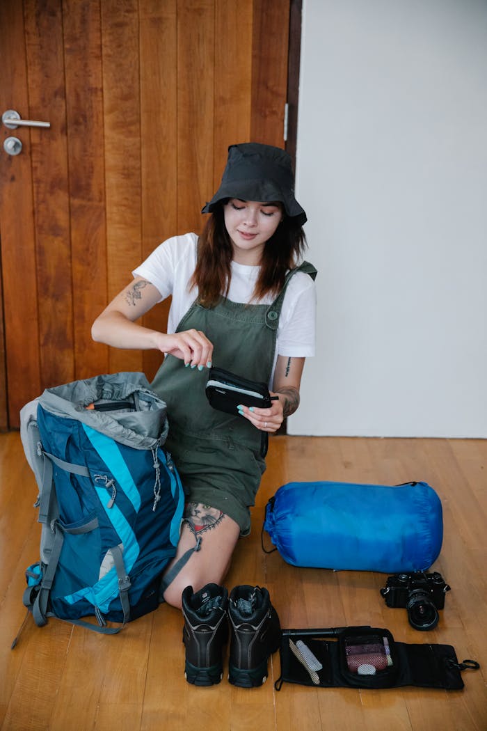 A Woman Preparing to Travel Packing her Stuff in a Back Pack